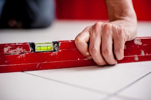 An image of a red measuring tool and hand of reliable builder