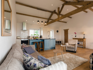 A living room with neutral colour palette and exposed wooden beams