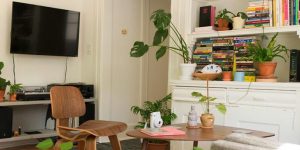 A white living room featuring a coffee table, tv, and bookshelf