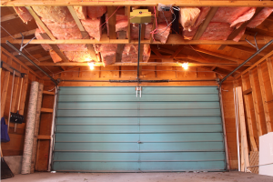 An empty garage with a teal door