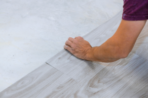 A man part way through laying flooring