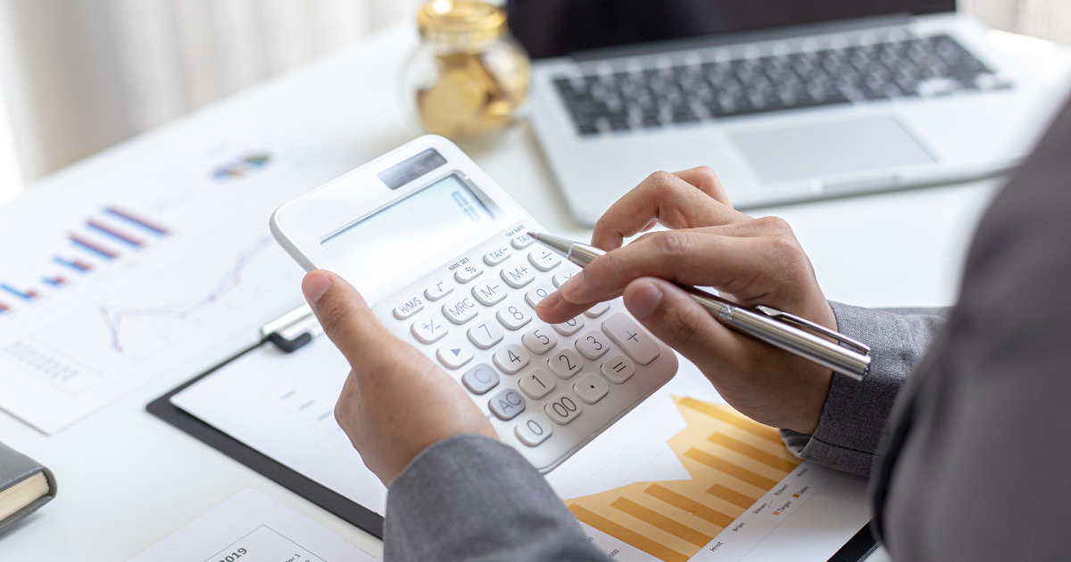 person typing into calculator