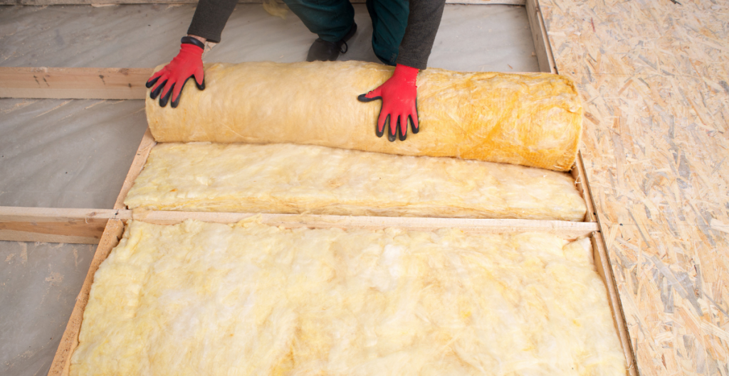 Insulation being rolled into the floor of an old home renovation